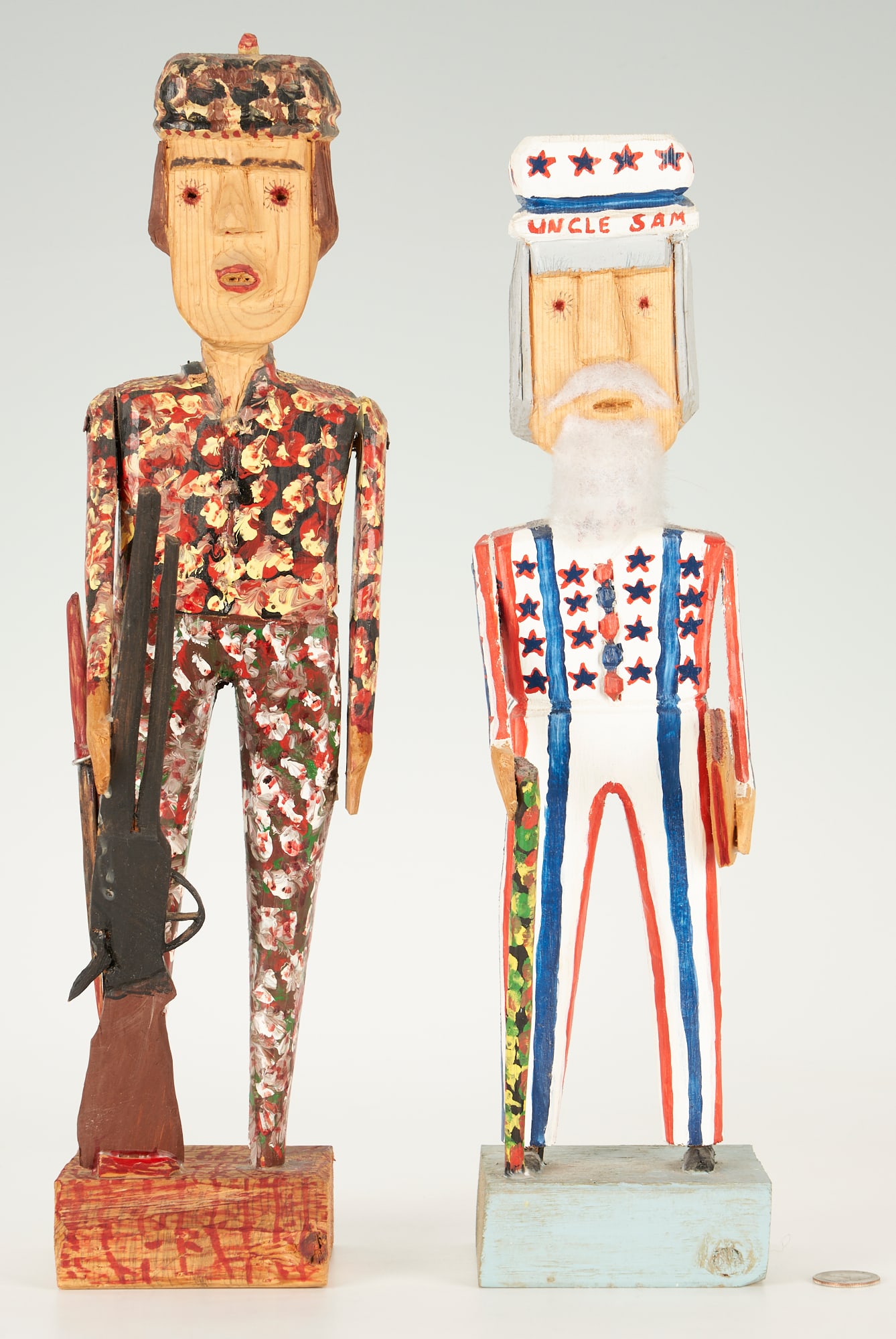 2 Carl McKenzie Figures, Uncle Sam & Daniel Boone: Carl McKenzie (Kentucky, 1905-1998), two carved wood figures. 1st item: "Uncle Sam," with cotton beard, 16", signed in marker underside of base. 2nd item: "Daniel Boone with Rifle," 17 1/2" H, signed