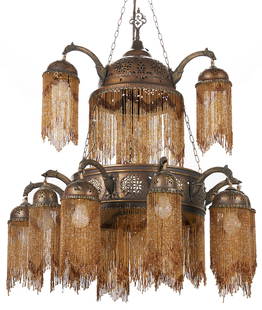 Moroccan Style Pierced Copper and Beaded Chandelier, ex - Naomi Judd: Moroccan style pierced copper and beaded chandelier. Hammered and pierced copper frame in two graduated tiers with thirteen arms and 15-lights. Domed pierced brass shades suspended from eagle head for