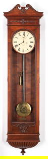 Seth Thomas Wall Regulator Clock: Seth Thomas wall regulator clock, single weight driven movement and engraved brass pendulum, enamel dial with Roman numerals, in a mahogany case with carved swan's neck pediment, husk and foliate carv