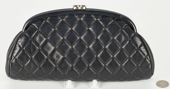 Chanel Quilted Lambskin Timeless Clutch: Chanel quilted black lambskin timeless clutch, with CC logo silvertone hardware and burgandy leather interior. Interior with serial number label reading #11057984. 6" H x 10 3/4" W x 2" D. PROVENANCE: