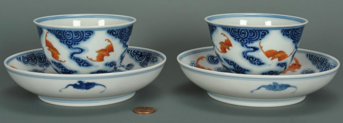 Pair Chinese Porcelain Cups & Saucers: Pair of Chinese porcelain cups and saucers with white ground with iron red bat decoration amidst blue ruyi clouds to the interior and blue bats to the exterior. Cups with blue Hsuan Mark. Saucers with