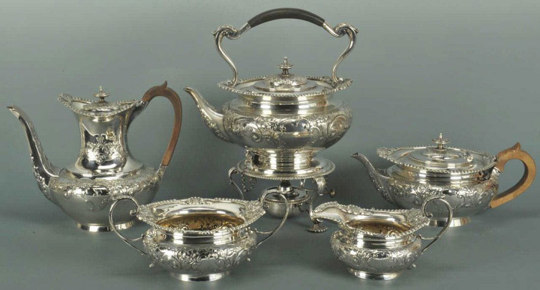 5 Piece Edwardian Sterling Tea Set: Edwardian sterling silver tea service including coffee pot (8" H x 9 3/4" W), tea pot (5 1/4" H x 10 3/4" W), warming pot with stand (12" H x 10 1/4" W), sugar (4" H x 8 3/4" W), and creamer (4" H x 7