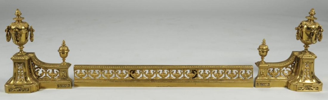 Gilded Fireplace Chenets and Fender: French gilded metal (probably brass) fire place chenets in the style of urns on pierced supports, together with a pierced fender, late 19th century. Each chenet: 14" H x 4-1/4" D x 11" W, Fender: 30" 