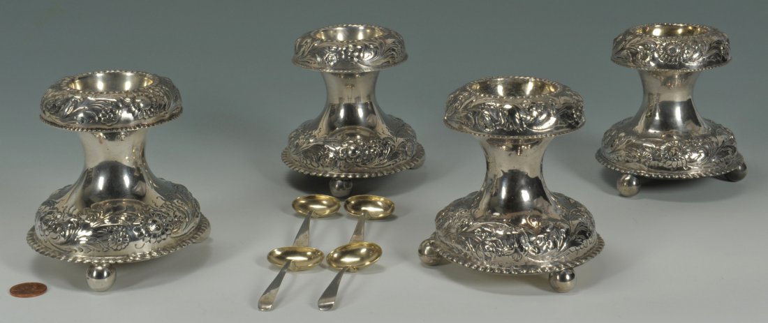 4 European standing silver salt cellars & 1 spoon: A pair of early silver standing salt cellars of circular, waisted form, the upper and lower body decorated with floral repousse decoration and crimped rims atop three ball feet. Gilt washed bowls. Wei