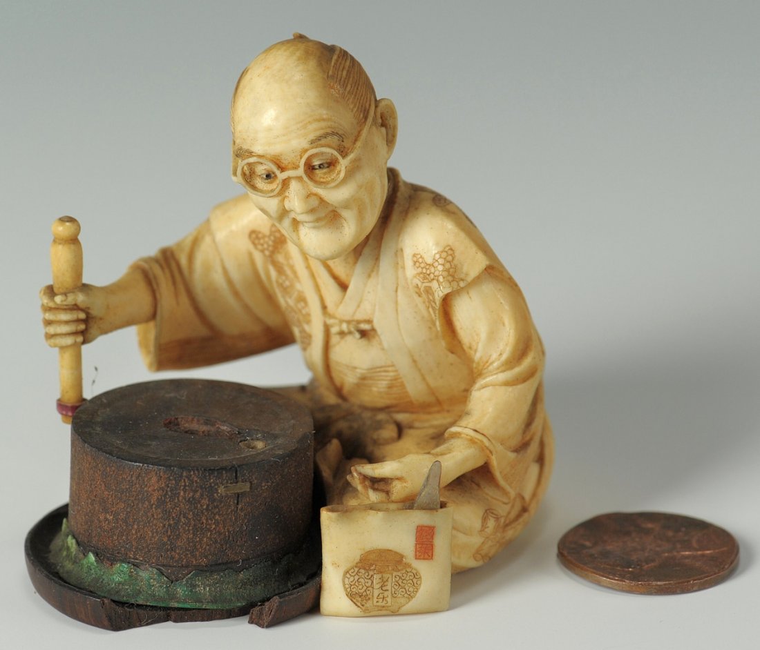 Japanese Ivory Figure, Male w/ glasses: Japanese Okimono figure depicting a seated male craftsman with glasses with wooden round work stand. Stands shows evidence of missing object. Red signature seal inset to underside of wooden stand. Red