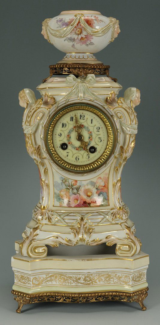 Porcelain KPM clock with stand, mid-19th c.: Porcelain KPM clock with stand, bombe sides with winged cherub figural mounts and floral, insect, swag and gilt decoration, topped by an oval urn on gilt ormolu mounts. A separate cartouche shaped por