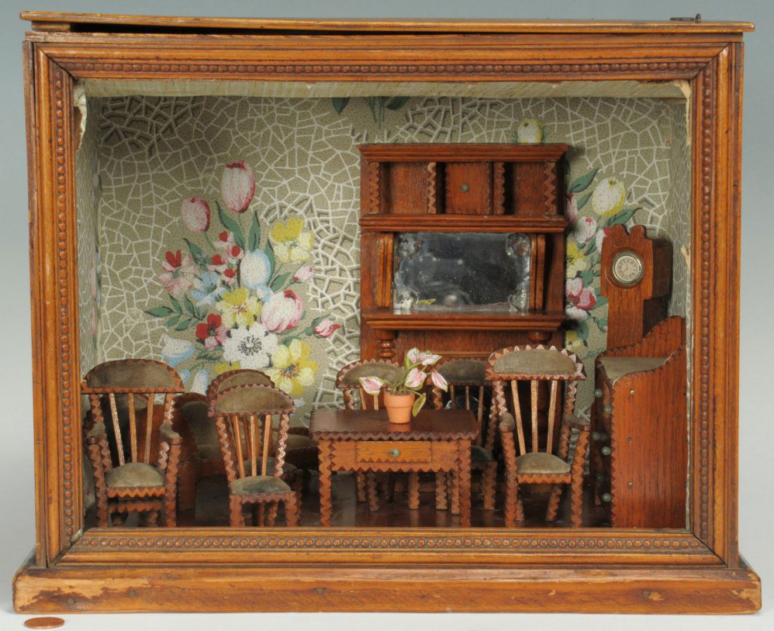 Miniature Folk Art Room Diorama: Miniature folk art room diorama depicting a parlor with tramp art style hand carved and upholstered furniture including a sofa, table, 4 chairs, mantle w/ fireplace, clock, dresser, and two armchairs.