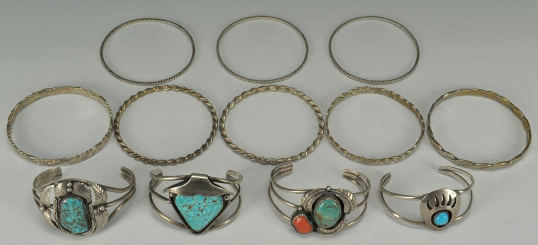 12 Native American Silver Bracelets: Grouping of 12 Native American silver bracelets including eight (8) bangle bracelets and four (4) cuff bracelets with turquoise and one with coral stones. All 20th century.