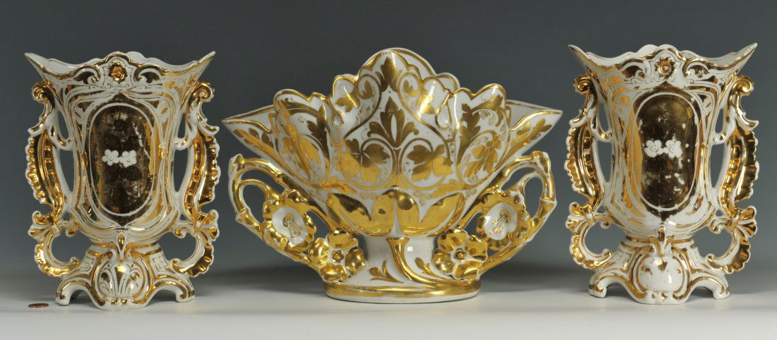 Old Paris Three Piece Garniture Set: Old Paris three piece garniture set with all over gilt decoration. Urn bases impressed "C or G 860". Jardiniere base impressed with "D" and "mirrored P". Urns - 9 1/2" H. Jardiniere measures - 9 1/2"