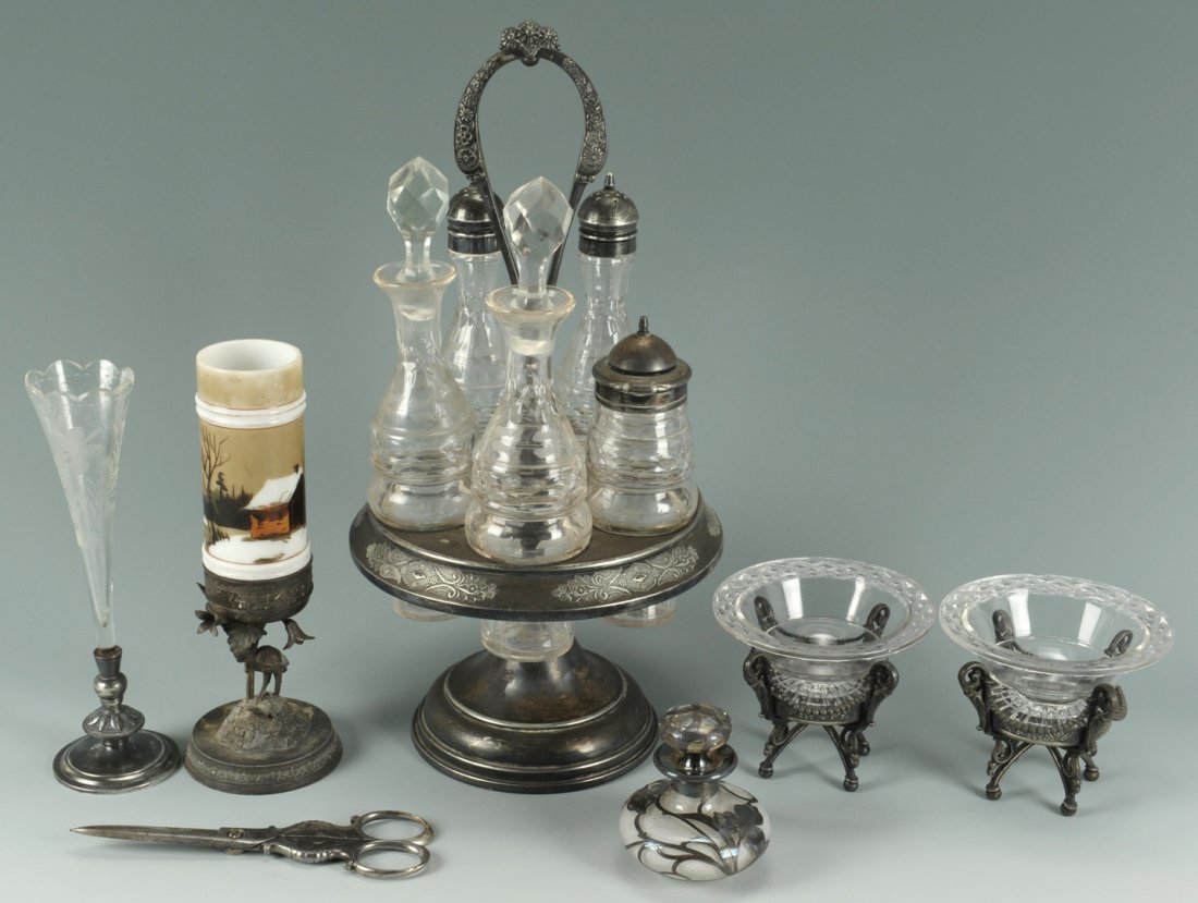 Six Victorian glass and silver items, most plated: Cruet/Caster set with five etched glass bottles in a round, silverplated frame (unmarked); a landscape painted glass vase on silverplated figural stand in the shape of a crane with foliage, marked on 