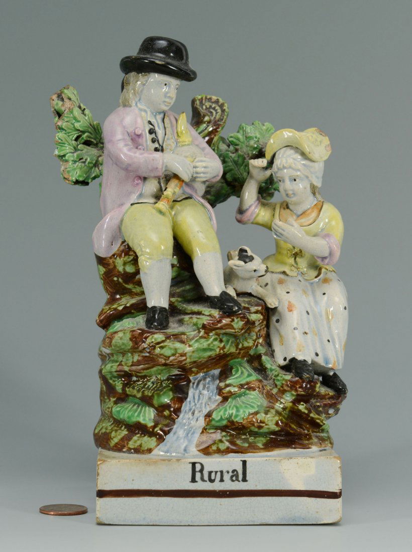 Early Pearlware Staffordshire "Rural" Figural scen: Early Staffordshire pearlware figural scene of a man and woman with bagpipes and calf, hand titled Rural on base. 7-1/2"H. English, circa 1825. Provenance: a Mississippi estate.