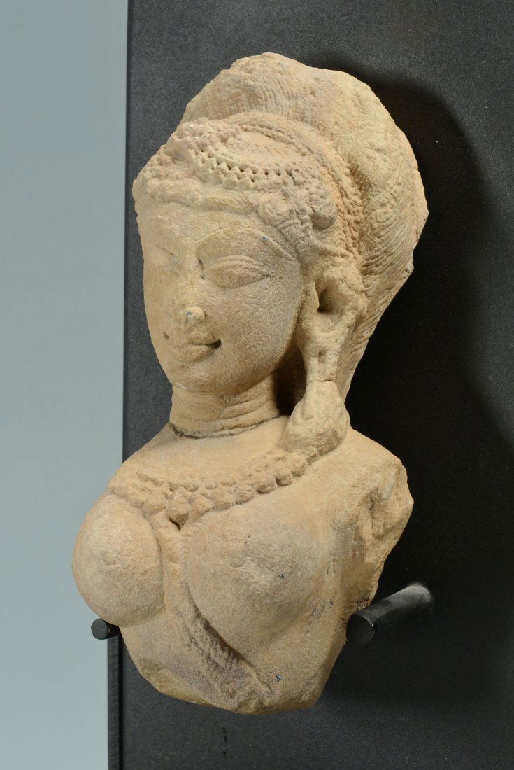 Hindu Goddess Stone Temple Carving: Hindu goddess stone temple carving, a fragment from an Indian temple of a female torso, carved from reddish stone. 7 1/2" H. 12-14th century. Fitted with a later custom metal display stand, 12&qu