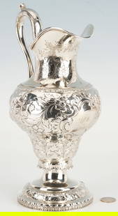 American 19th C. Coin Silver Pitcher: American mid 19th Century Coin Silver Ewer or Pitcher, with elaborate chased and repousse floral scroll decoration, cartouche under spout engraved "Presented to L_M by CWM." Raised on a circ