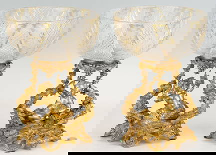 Pair Ormolu and Cut Glass Compotes: Pair of Moser style crystal compotes or tazzas, featuring amber cut-to-clear and floral engraved glass bowls mounted to gilt bronze openwork pedestals modeled as cherubs surrounded by