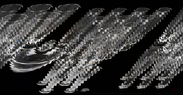 27 Pcs. of Steuben and Lalique Glassware: 27 pieces of Steuben and Lalique glassware, including: ten (10) Steuben slender glasses (6 in. H); six (6) Steuben tall hourglass form glasses (6 1/2 in. H); six (6) Steuben hourglass form cordials (4