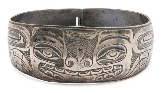 Native American Haida Sterling Cuff Bracelet: Native American sterling silver Haida cuff bracelet with engraved mask and other traditional designs, and a hinged clasp. Cuff width at widest point 1in., interior circumference 7 1/4 in. Early 20th c