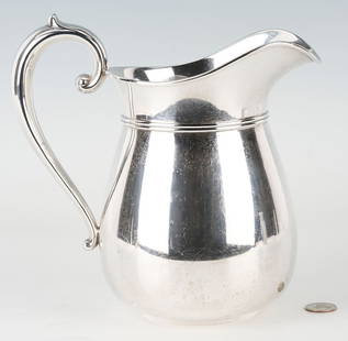 Baker Manchester Sterling Water Pitcher: Sterling silver water pitcher by Baker Manchester, bulbous helmet form with C handle. Marked to the underside "Sterling 1009 4 1/2 PT." together with maker's hallmark. Measures 9 in. H.1