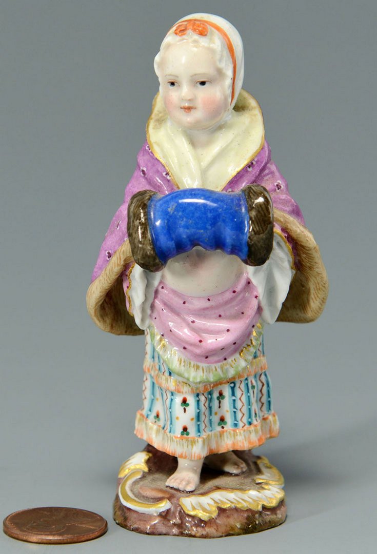 Small Meissen Figurine, girl with muff: Small Meissen figure of girl dressed in a winter coat and holding a muff, but bare footed, on a scrolled base. Impressed mark "No. 1" to base with additional iron red mark and crossed swords