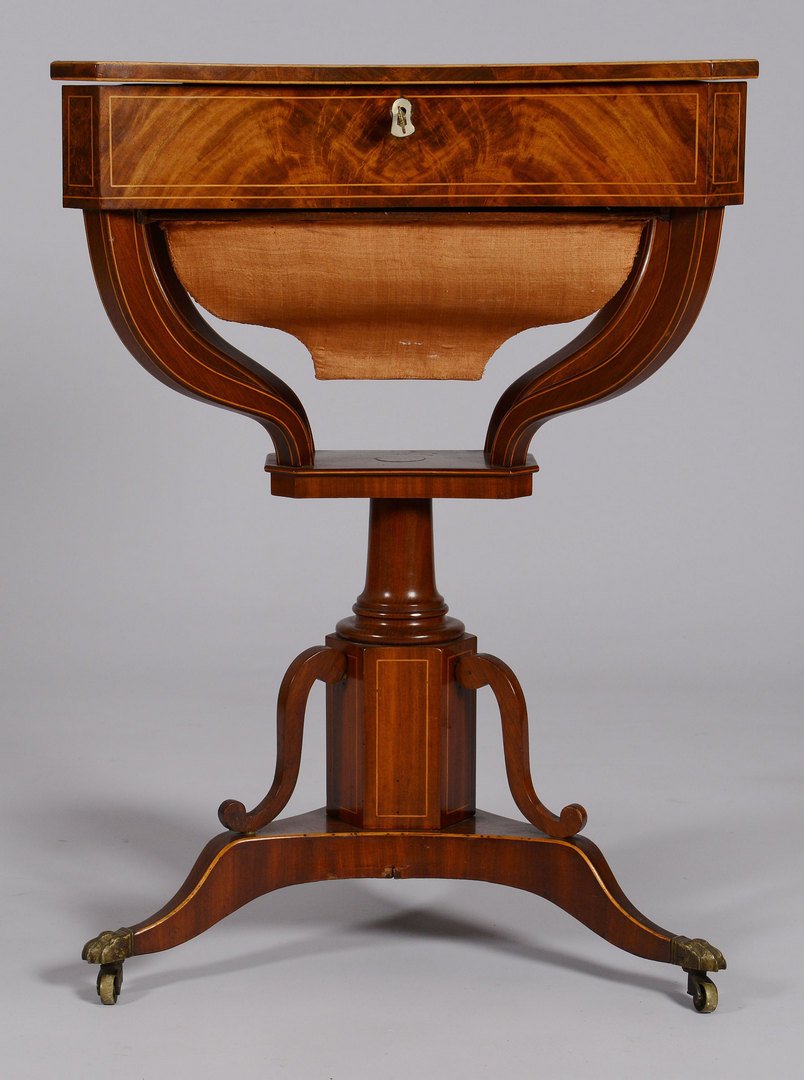 Inlaid Classical Sewing Stand, Possibly English: Inlaid mahogany classical sewing stand having a shaped lift top with sting inlay, ivory escutcheon and fitted interior, supported on turned column and tripod base with brass paw feet. 29 1/4" H x
