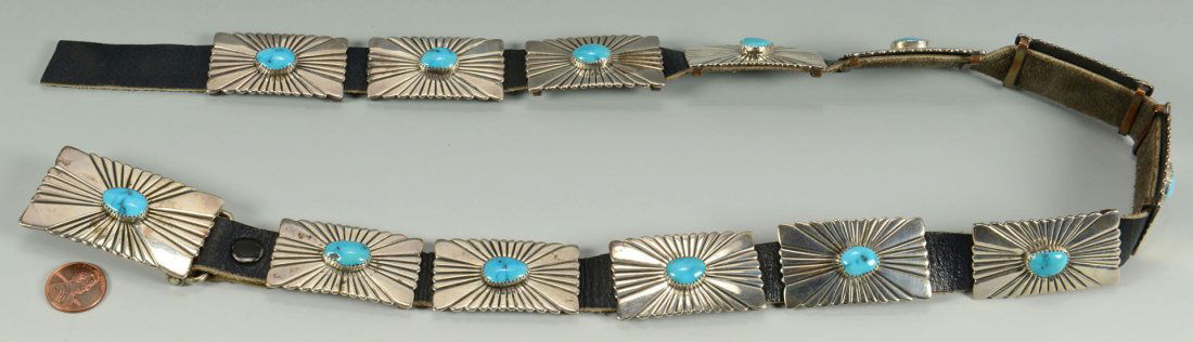 Navajo Silver and Turquoise Concho Belt: Native American silver concho belt, thirteen rectangular links on a leather background, all with sunburst design centered by an oval turquoise. Ladies small size. 31" overall. Mark for Wilson Beg