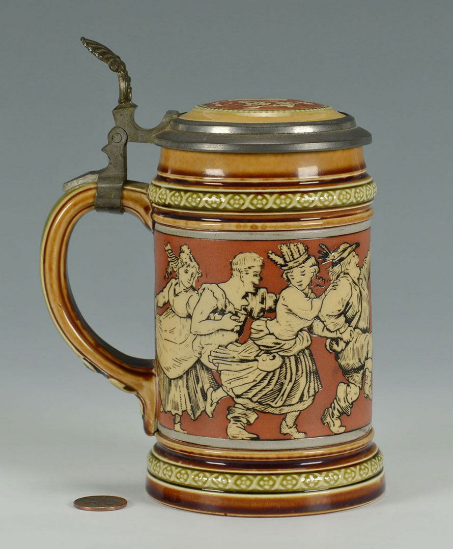Mettlach Stein #2057 Dancer's on Red Ground: Mettlach/Villeroy & Bach Stein #2057 featuring incised painted dancer's and bagpipe player decoration on a red ground. Pewter and pottery top and handle, 3/10 liter capacity. 6 1/2" H. Early 20th
