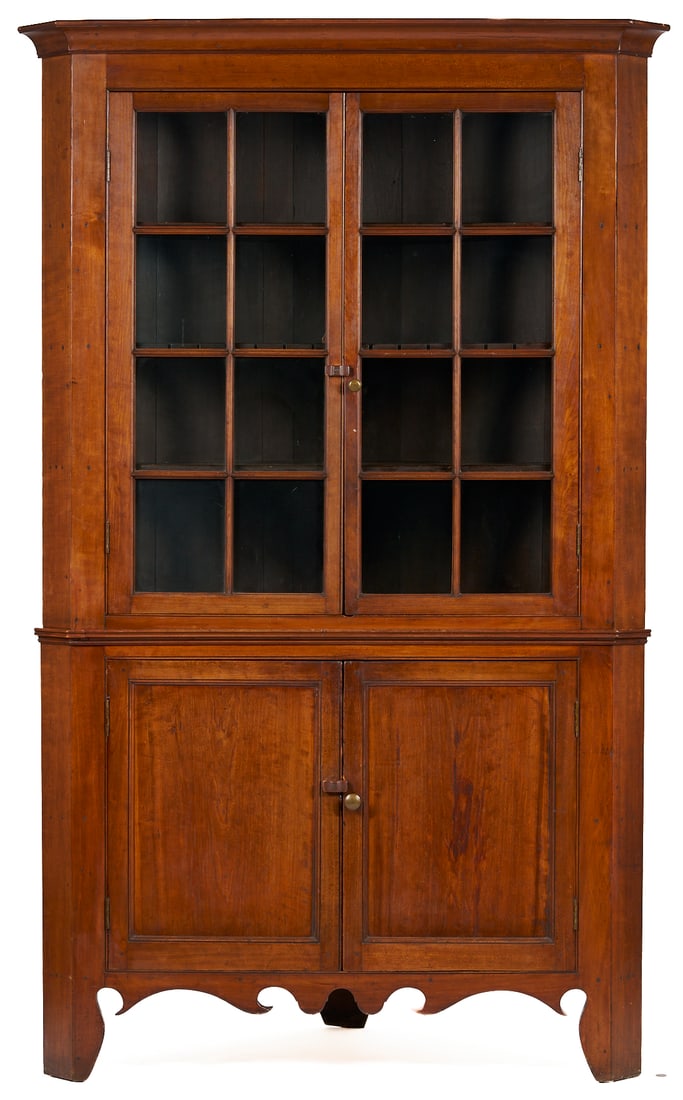 East Tennessee 2-Piece 16-Pane Corner Cupboard, c. 1820: East Tennessee cherry corner cupboard, poplar secondary. Two-piece form, the upper section with a cove-molded cornice and a plain frieze over sixteen glazed panel doors opening to four interior s