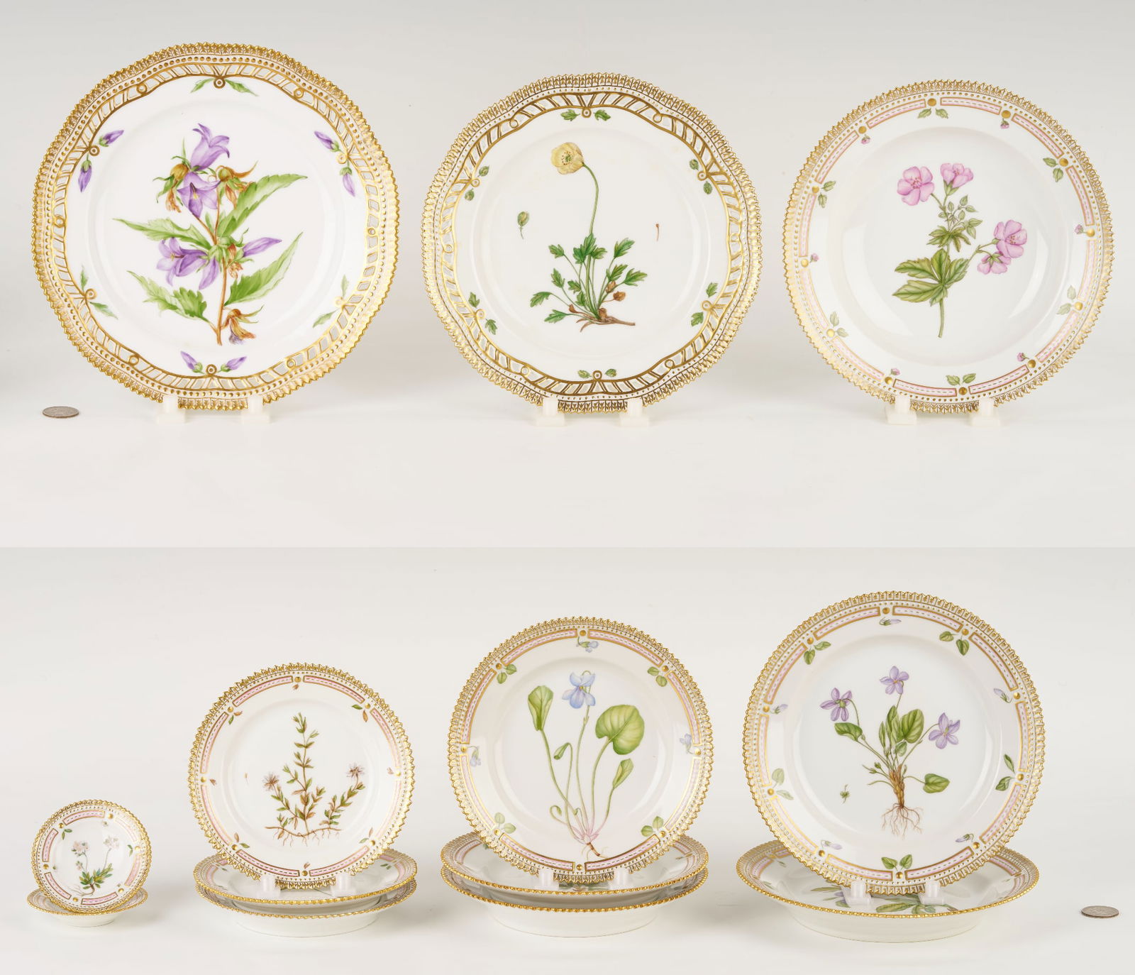 13 Pieces of Royal Copenhagen Flora Danica Porcelain Dinnerware: Thirteen (13) pieces of Royal Copenhagen Flora Danica Porcelain Dinnerware with gold borders, including one pierced luncheon plate (9 5/8 in. dia.) marked Campanula trachelium L., one smaller pierced