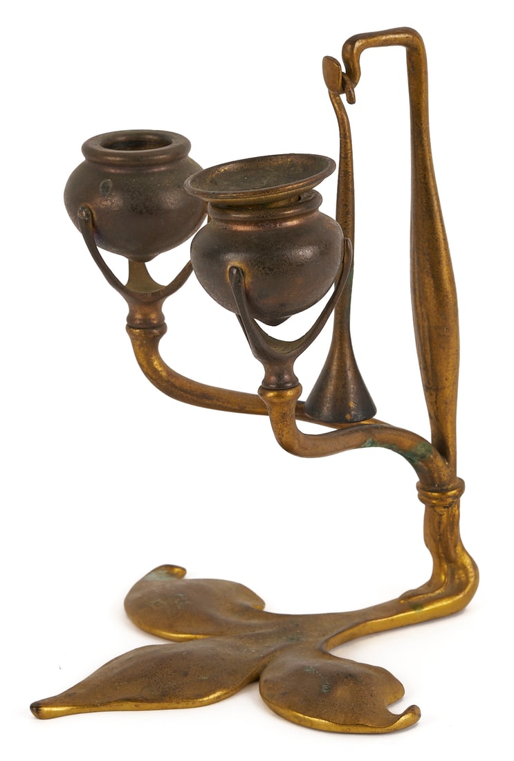 Tiffany Bronze Fleur di Lis Candlestick: Tiffany Studios bronze Fleur di Lis double holder candlestick with original hanging snuffer. Signed to underside of base, #1232. 8 1/2 in. H x 6 1/2 in. W x 7 1/2 in. D. Circa
