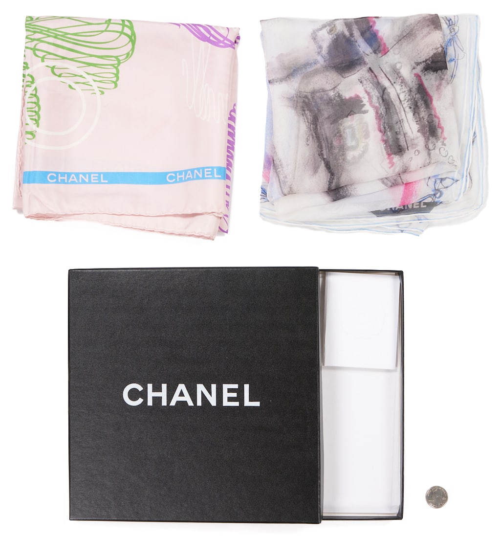 2 Silk Chanel Scarves incl. Eiffel Tower and Karl Lagerfeld: Two (2) Chanel silk scarves, including one (1) in a colorful graphic style depicting the Eiffel Tower, lucky clover, bow, and number "5" on a pale pink ground with a blue border featuring th