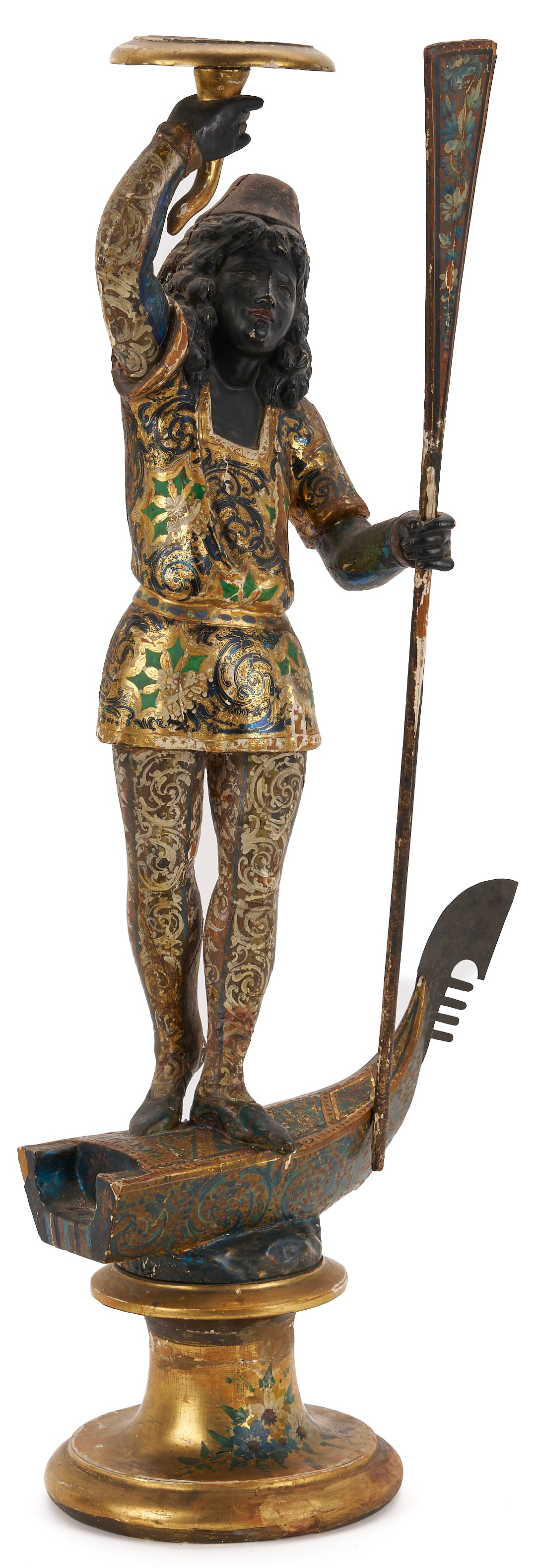 Carved Blackamoor Torchiere, Venetian Gondolier: Continental school, likely Italian, carved wood polychrome and gilt blackamoor figure that depicts a young man who stands on a partial, diminutive Venetian gondola with metal fero da pr