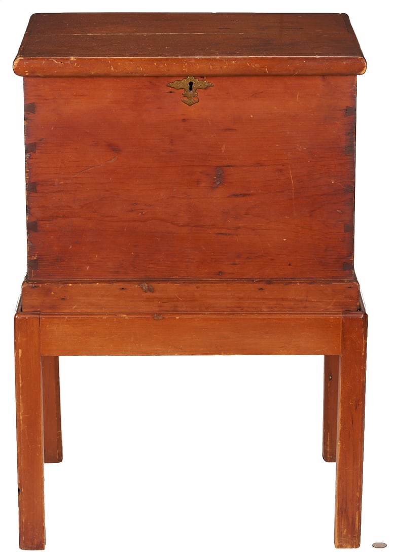American Cherry Cellaret: American cherry and white pine cellaret form or bottle case. Hinged top with rounded molded edges over a dovetailed case with batwing brass escutcheon, opening to a fitted, velvet-lined interior.