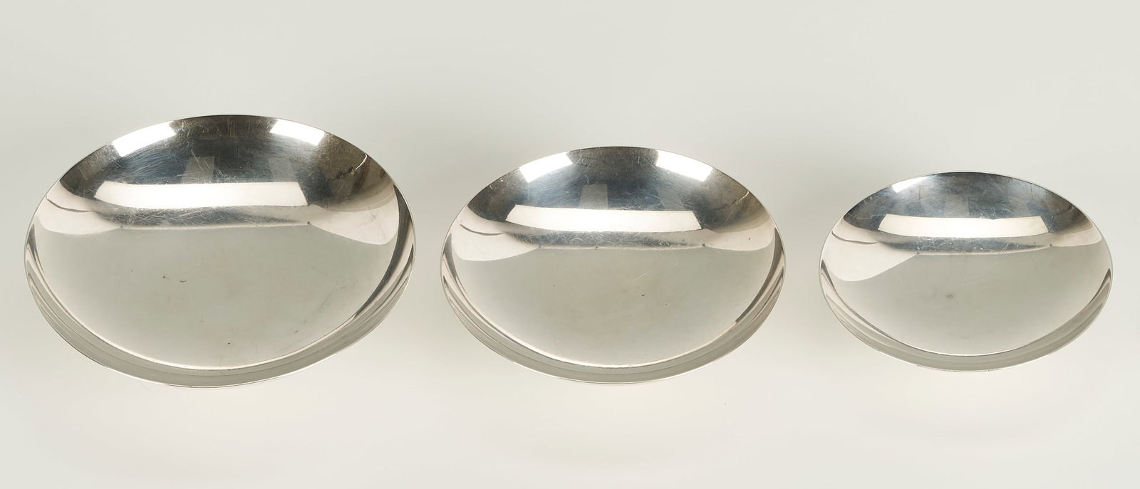 Japanese Silver Sake Bowl Set 3 pc: Set of 3 graduated Japanese silver sake bowls, each of circular form with pedestal foot, hallmarked with Jungin mark for pure silver (.950/1000 +), ranging from 3 1/2 to 4 3/4 in. diameter. Stacked: 2