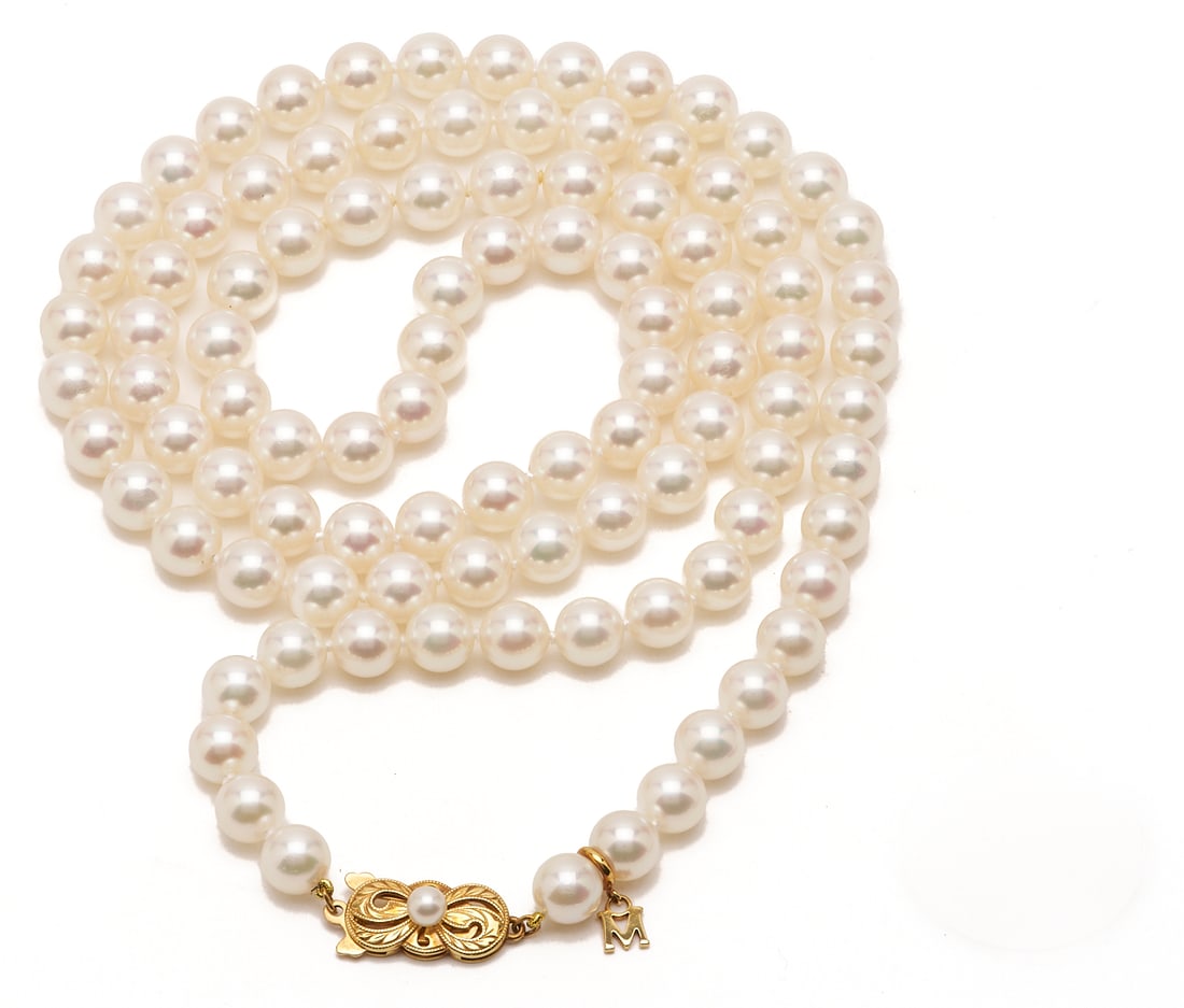 Ladies' Mikimoto Pearl Necklace, 18K Gold Clasp: Ladies' single-strand Mikimoto pearl necklace consisting of ninety-eight pearls that measure 7.5 x 7.0 mm. White in color with pink overtones and high lustre. Strung knotted with an 18K yellow gold cl