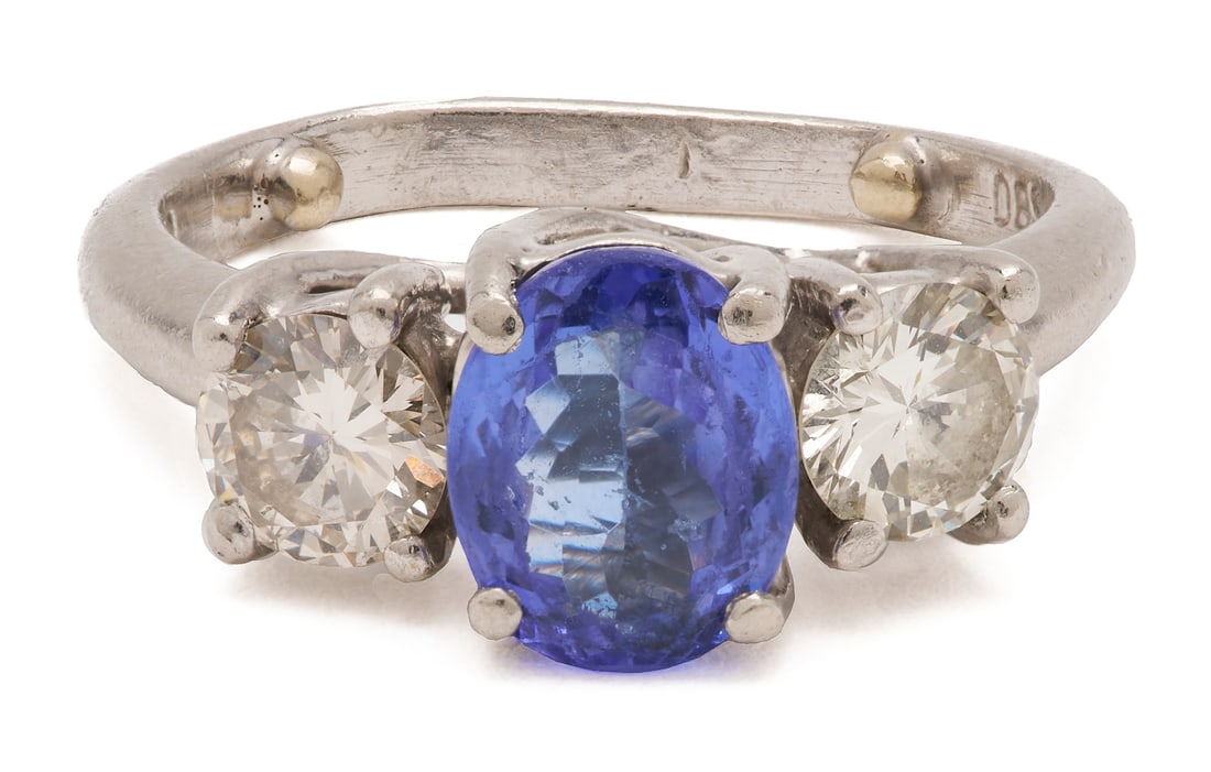 Ladies' Platinum, Natural Tanzanite, & Diamond Ring: Ladies' platinum ring featuring one (1) natural oval cut tanzanite accented by two (2) round brilliant cut diamonds, approximately 1.08 carats together, Clarity-SI1, Color-G. The ring is marked