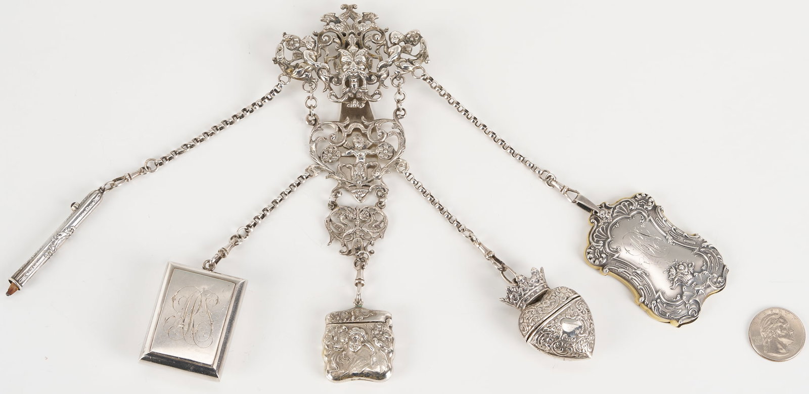 Silver Chatelaine: Continental Silver chatelaine with Bacchus mask and caryatid figures on a pierced cartouche, bearing Hanau hallmarks, with attached vinaigrette, pencil, match box, and heart-shaped box (all unmar