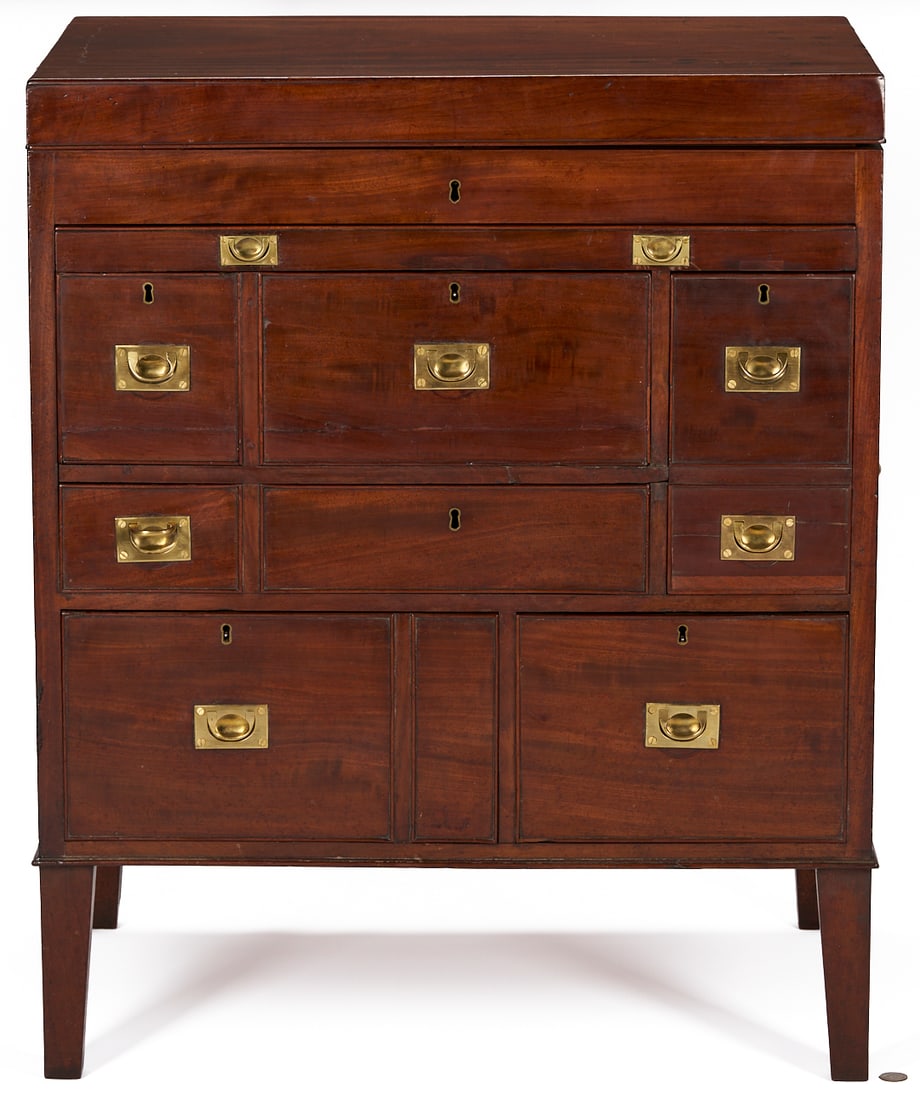 British Mahogany Campaign or Dressing Chest: George III mahogany gentleman's campaign dressing bureau or Beau Brummel. Hinged top lifts to reveal a shallow storage well, over dovetailed drawers of various depths and sizes (some with fa