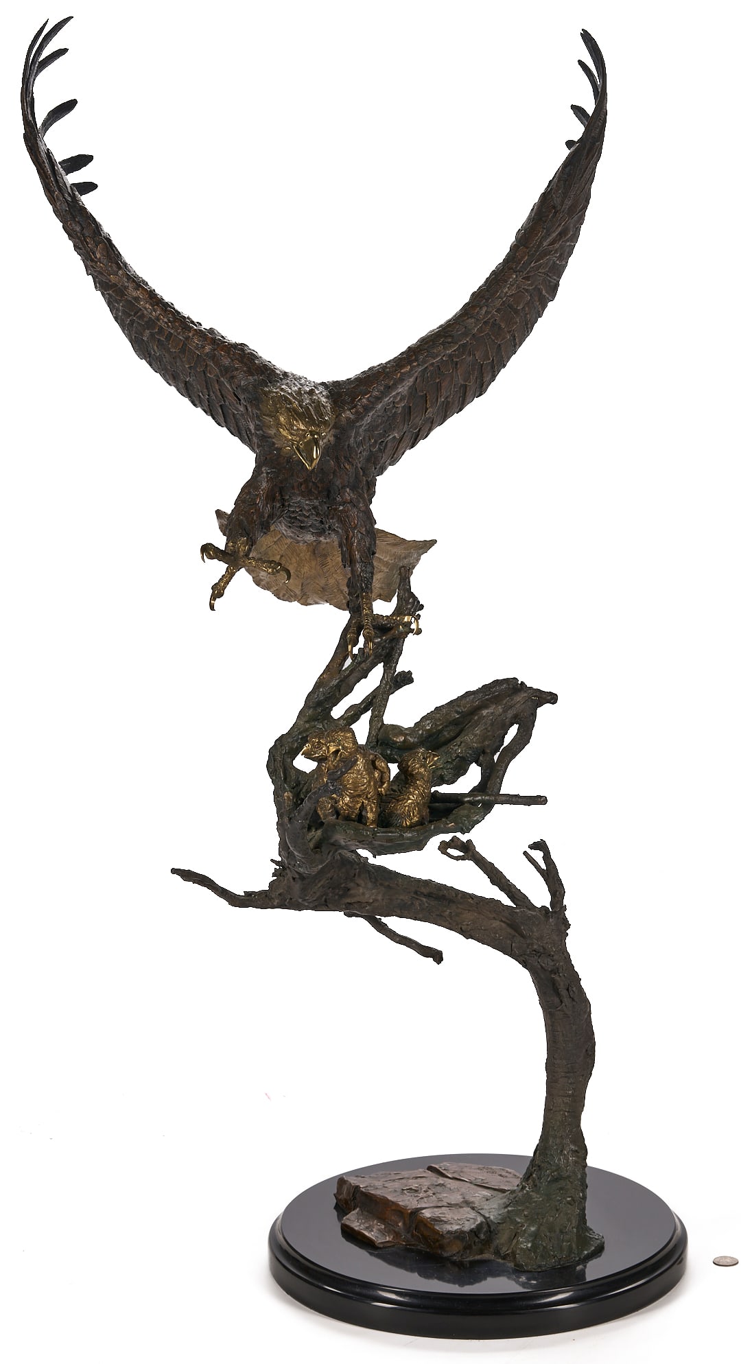 Laran Ghiglieri Bronze Sculpture, Nesting Eagle; Gemstone Eyes: Laran Ghiglieri (American, b.1944) patinated bronze sculpture of a bald eagle swooping down onto a nest of eaglets. Each bird has been embellished with gemstone eyes; the large eagle with diamond