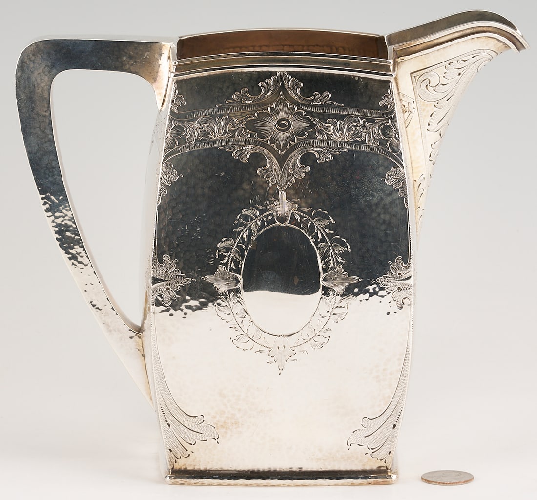 Schofield Art Deco Sterling Water Pitcher: Schofield Art Deco era hand hammered sterling silver pitcher, square base and body with slightly curved sides and square handle, engraved foliate scroll decoration to shoulders and corners. Vacant