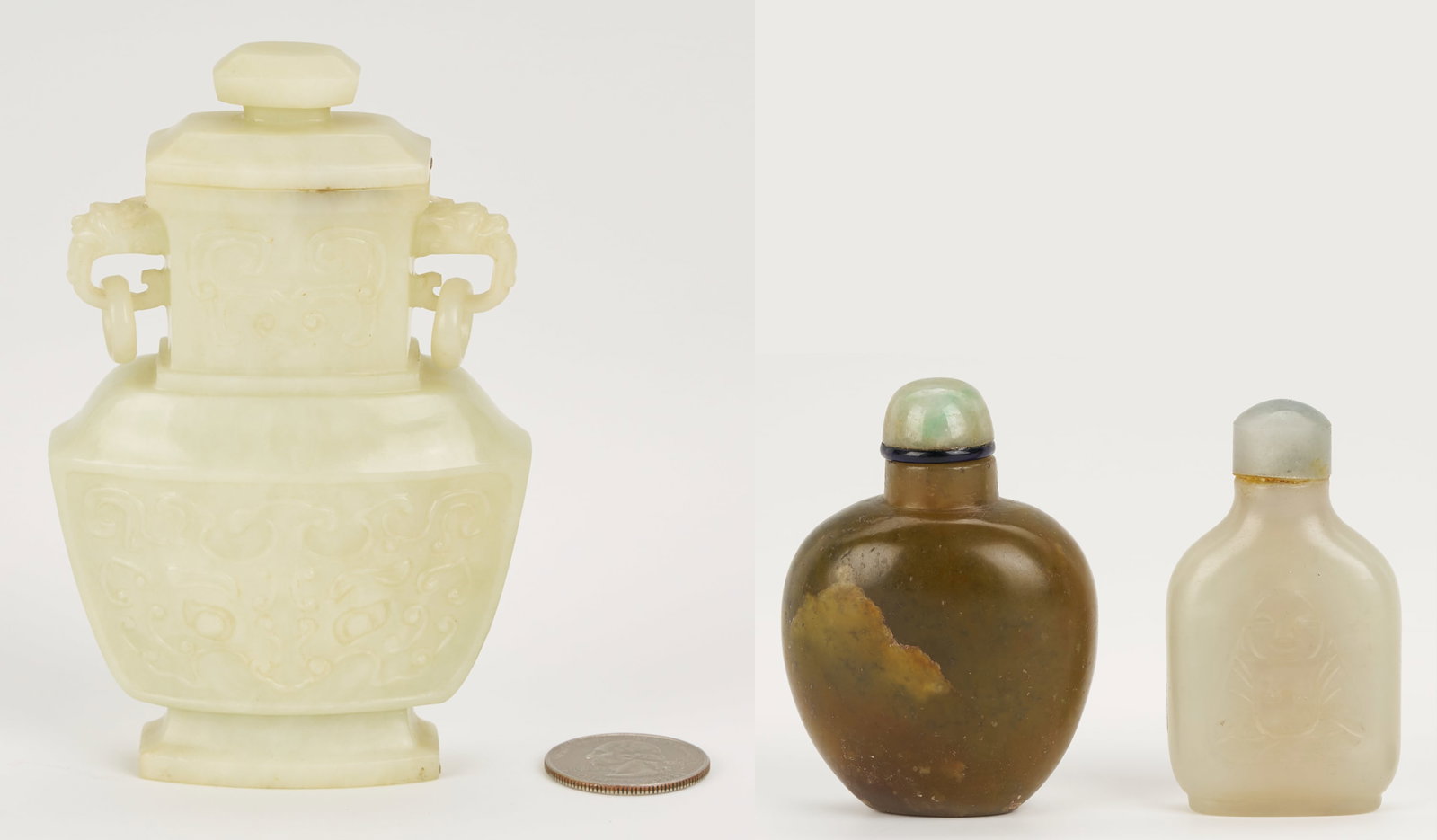 Chinese Miniature Jade Covered Urn & 2 Jade Snuff Bottles: 1st item: Chinese miniature nephrite jade lidded urn, flattened form with carved taotie mask decoration to the body, bat decoration to the neck, and foo dog finials with rings. 4 3/8 in. H. 20th