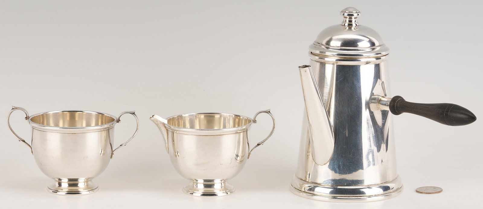 3 Sterling Silver Items: Chocolate Pot, Creamer, & Sugar: A sterling silver diminutive chocolate pot in the 18th century-style, plus an associated sterling cream and sugar set. Pot: 6 1/2 in. H. Gross weight: 17.36 oz troy. All American, mid-20th