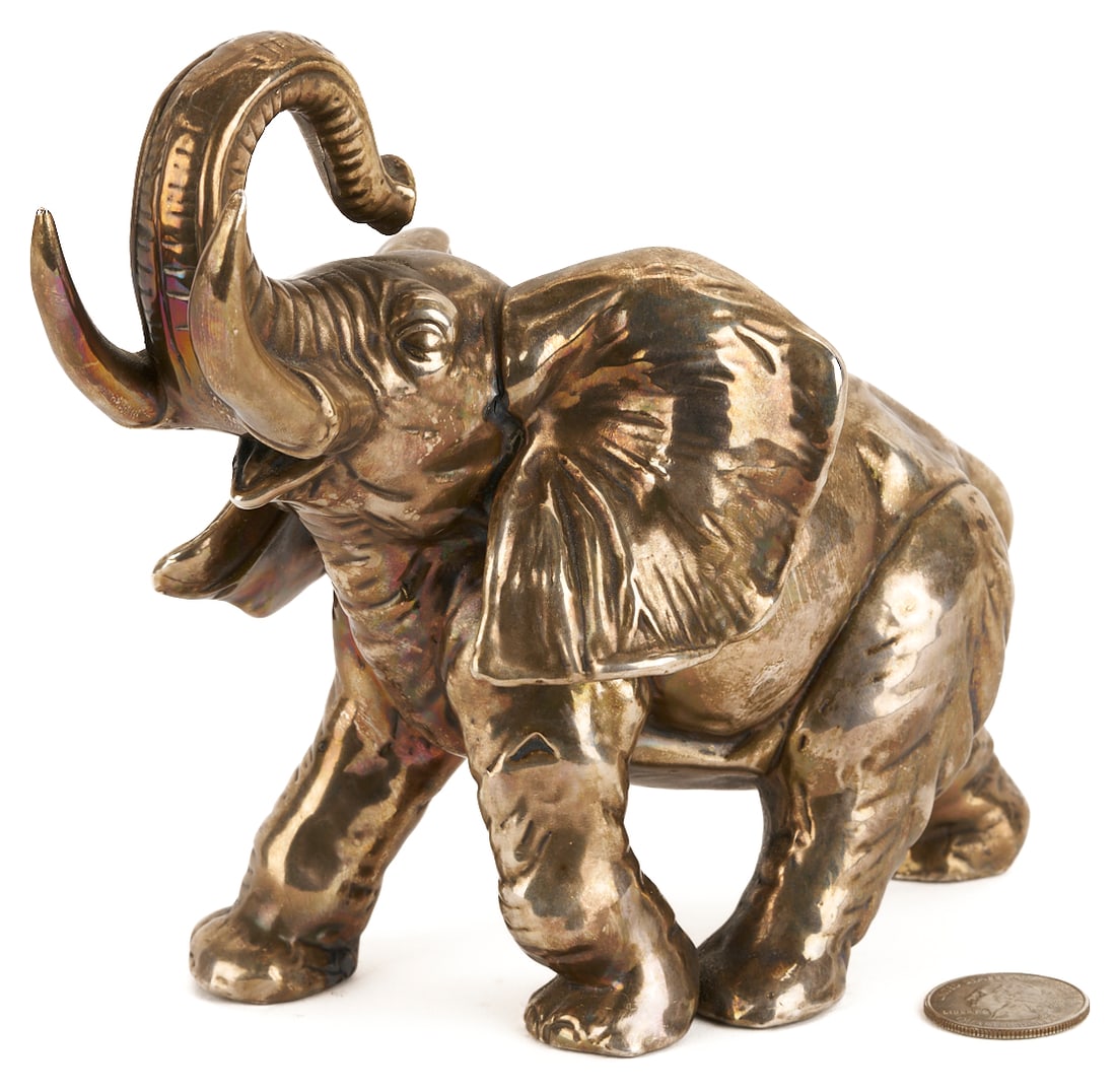 Asian Silver Elephant: Sterling silver-clad elephant sculpture. Expressively posed in a walking position, with a raised trunk, open mouth, and flared ears. Stamped .925. 8 1/2 in. L x 6 1/2 in. W. 20th