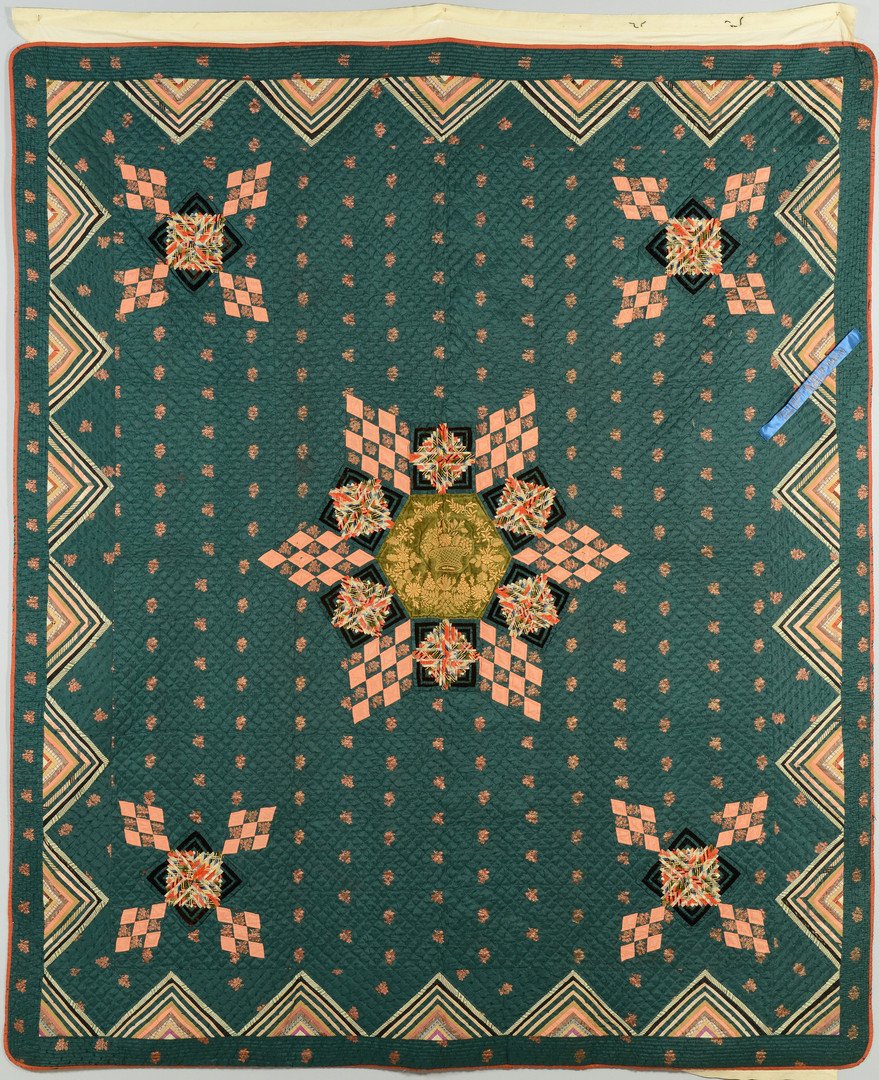 1909 TN State Fair First Place Quilt: Tennessee pieced quilt, star variant pattern, comprised primarily of satin and velvet, dark green background color with other colors including peach, rust, and black. Blue prize ribbon attached to qui