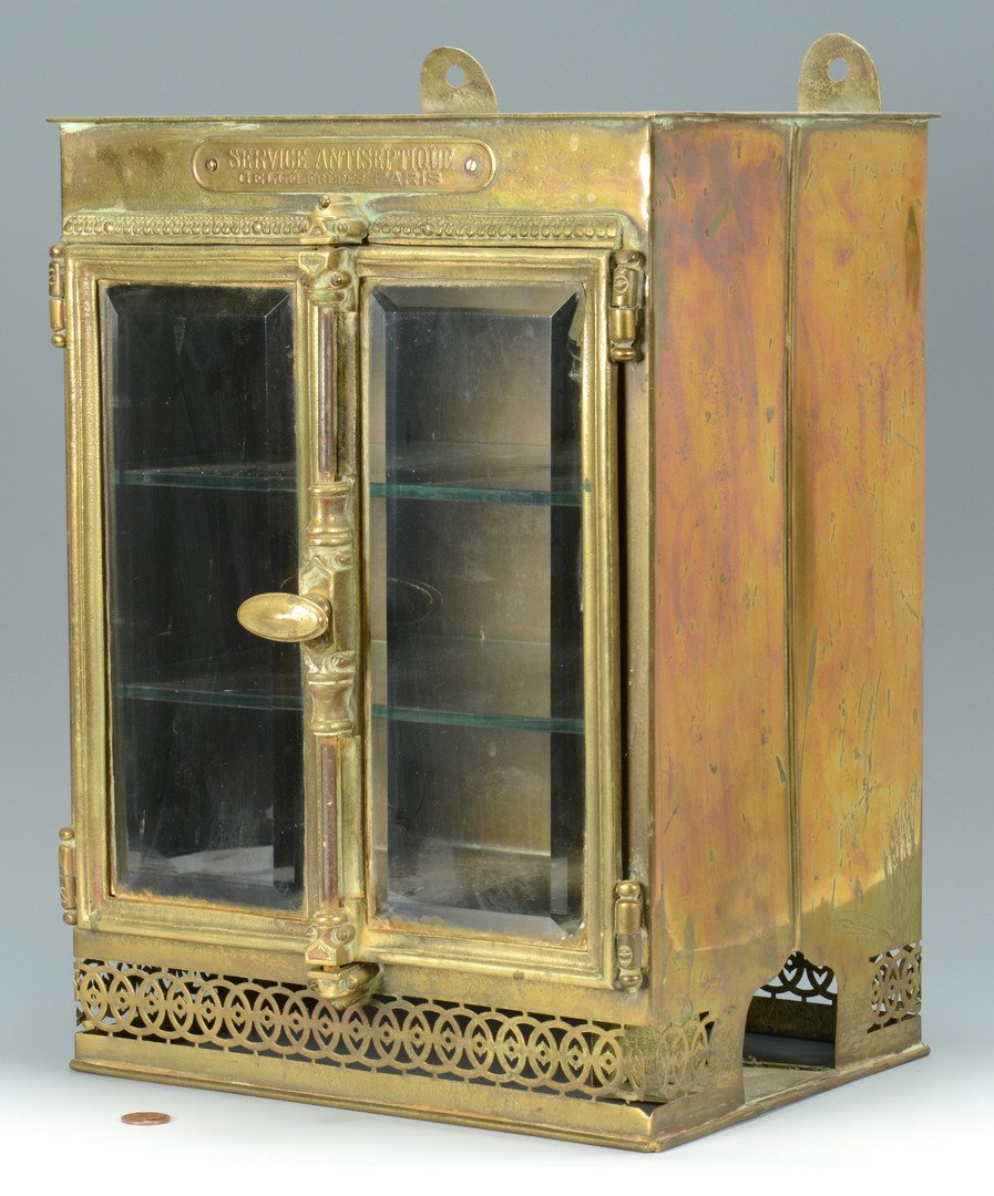 French Brass Perfume Cabinet, 19th c.: French brass apothecary or eau de parfum cabinet, with brass plate reading "Service Antiseptique / Gelle Freres, Paris". Rectangular hanging cabinet with beveled glass doors and two interior removable