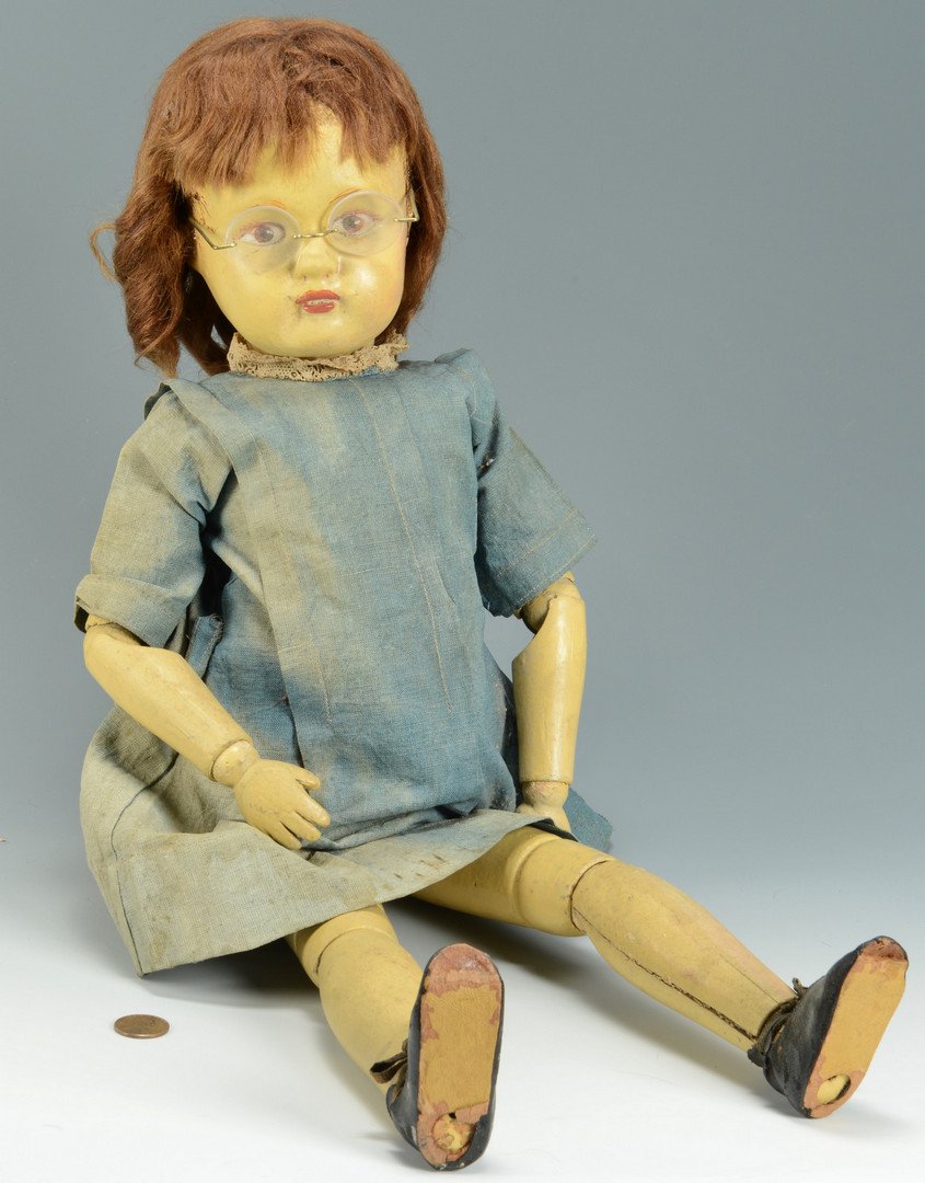 Schoenhut Character Doll with glasses: Schoenhut carved and painted character doll with brown eyes, eyeglasses and blue cotton dress with lace collar. Fully jointed body and brown wig. Marked on back. 21-1/2"L. Provenance: Estate of France