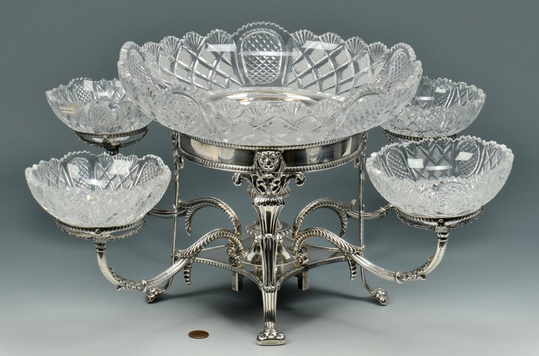Edwardian style Epergne: Edwardian style silver over copper and cut glass epergne with lion head and acanthus decoration on lion paw feet, with center glass bowl and 4 side serving bowls. Frame is unmarked but glass bowls are