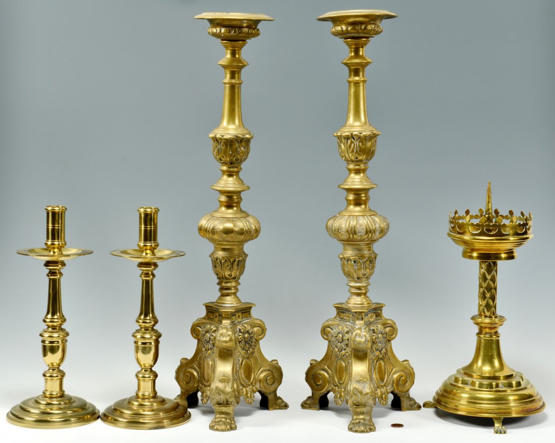 5 Tall Brass Candlesticks: Five tall brass candlesticks including a pair of Continental silvered brass altar candlesticks with overall foliate decoration and three paw feet (24" H), a single Continental brass alter candlestick 