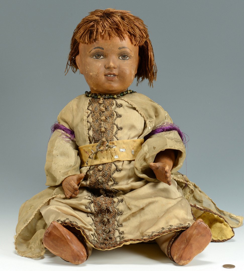 Leather, papier mache black doll: Paper mache black doll with kid-leather covered head and body, wearing a silk Moorish-style costume with braided metallic trim and beaded necklace. Painted facial features and body. No markings found.