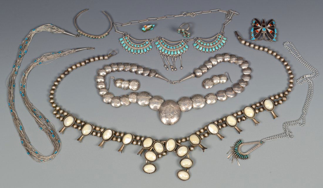 Group of 10 Indian Navajo items: Grouping of ten (10) Native American jewelry items including a Navajo silver squash blossom necklace with mother-of-pearl stones, a Zuni needlepoint silver pendant signed Garnett & Josie Owaleon with