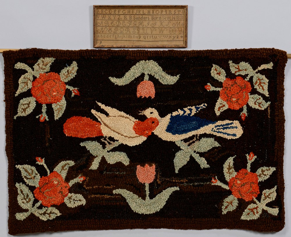 2 Folk Art Textile Items, Hooked Rug & Sampler: 1st item: Folk art hooked rug depicting two doves and a heart (which forms the head of one of the birds), surrounded by tulips and roses and set on a brown background. 26" x 39-1/2". Circa 1900. 2nd i