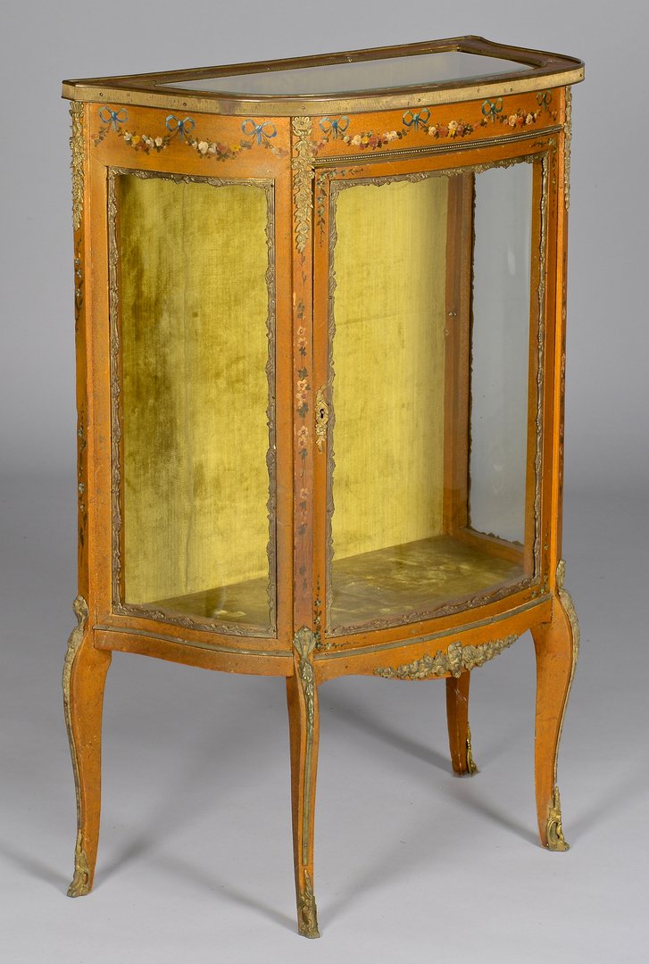 Vitrine w/ Painted Florals & Ormolu Mounts: Louis XV style painted and ormolu mounted vitrine with D-shaped beveled glass top, floral and leaf handpainted frieze over a curved single door and curved glass sides, all on four ormolu mounted cabri